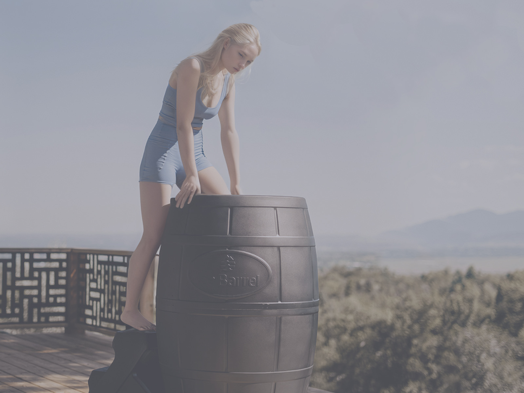 woman climbing into a cold plunge tub with mountains behind her