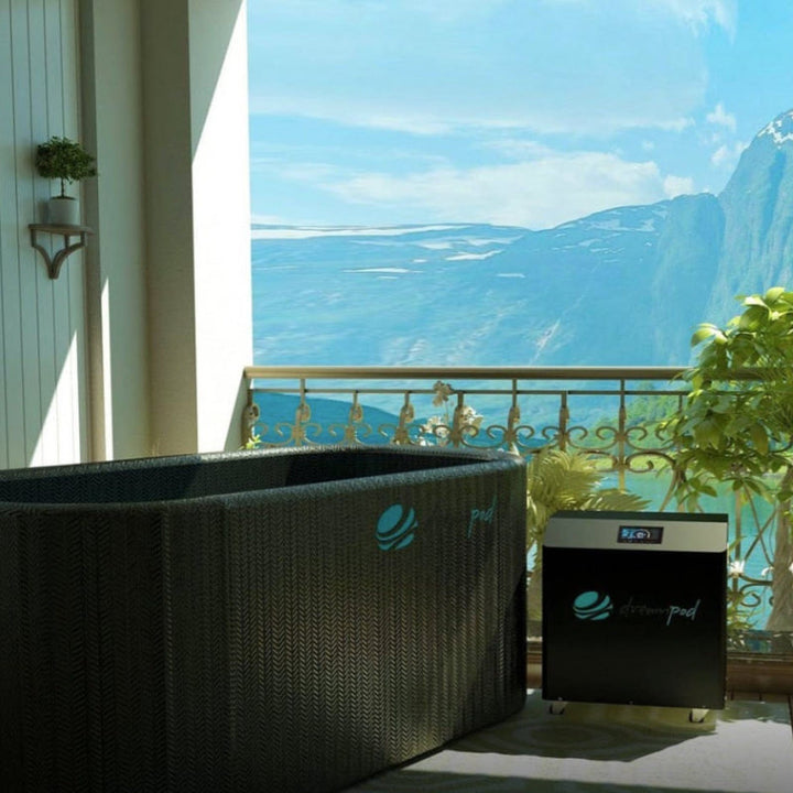 Dreampod's flexible ice bath sits inflated on a balcony overlooking mountains.