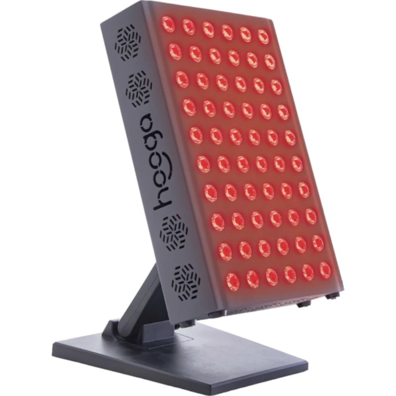 Hooga Pro300 Red light & infrared light therapy device sits on a table top. The light is on and shines red