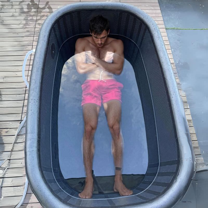 A man braces himself for the icey water in dreampod's inflated ice bath