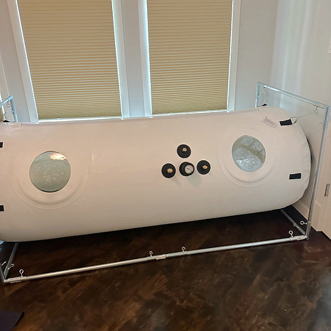 a user photo of Newtowne's 34" HBOT chamber. It is in a bedroom against windows.
