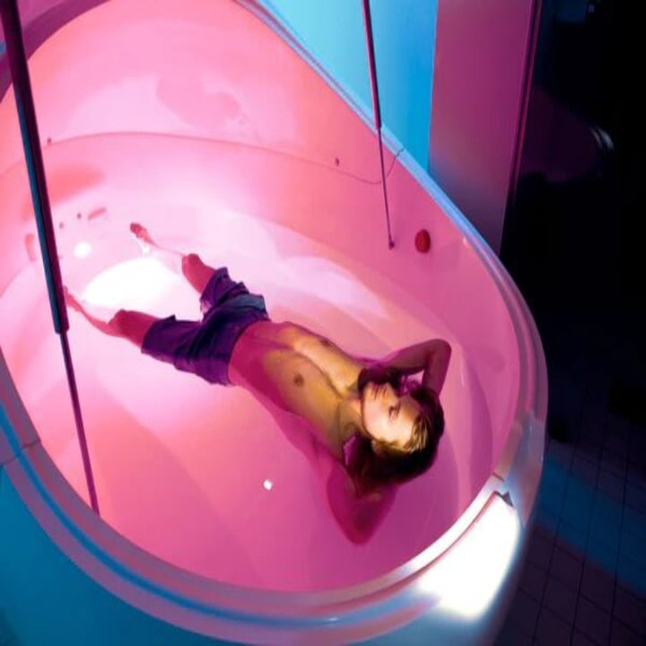 Relaxed Man In A Dreampod Vmax Float Pod With Pink Light