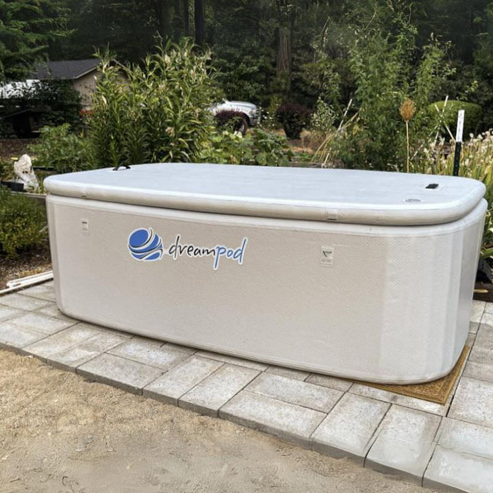 the dreampod home flex float tank sits outside with its lit on.