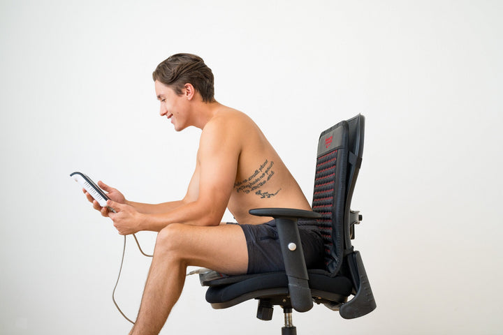 Person seated on the Hooga infrared PEMF chair mat during a session
