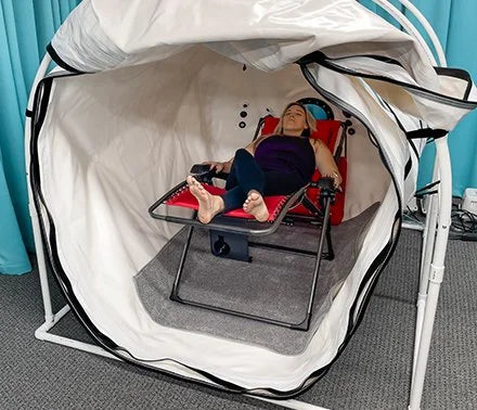 Woman resting on a lounge table inside the Summit to Sea Grand Dive Pro Plus chamber