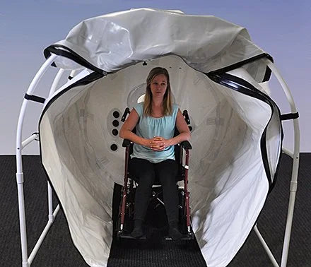 Woman seated in a wheelchair inside the Summit to Sea Grand Dive Pro Plus chamber